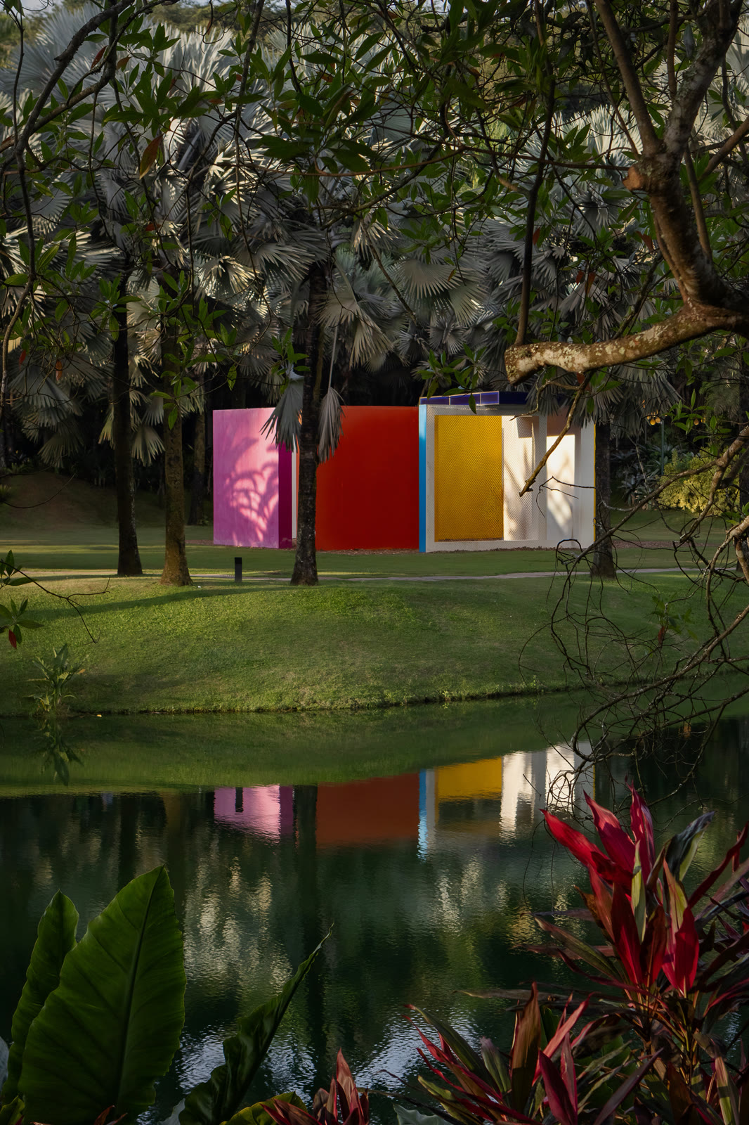 Pavilhão colorido refletido no lago de Inhotim